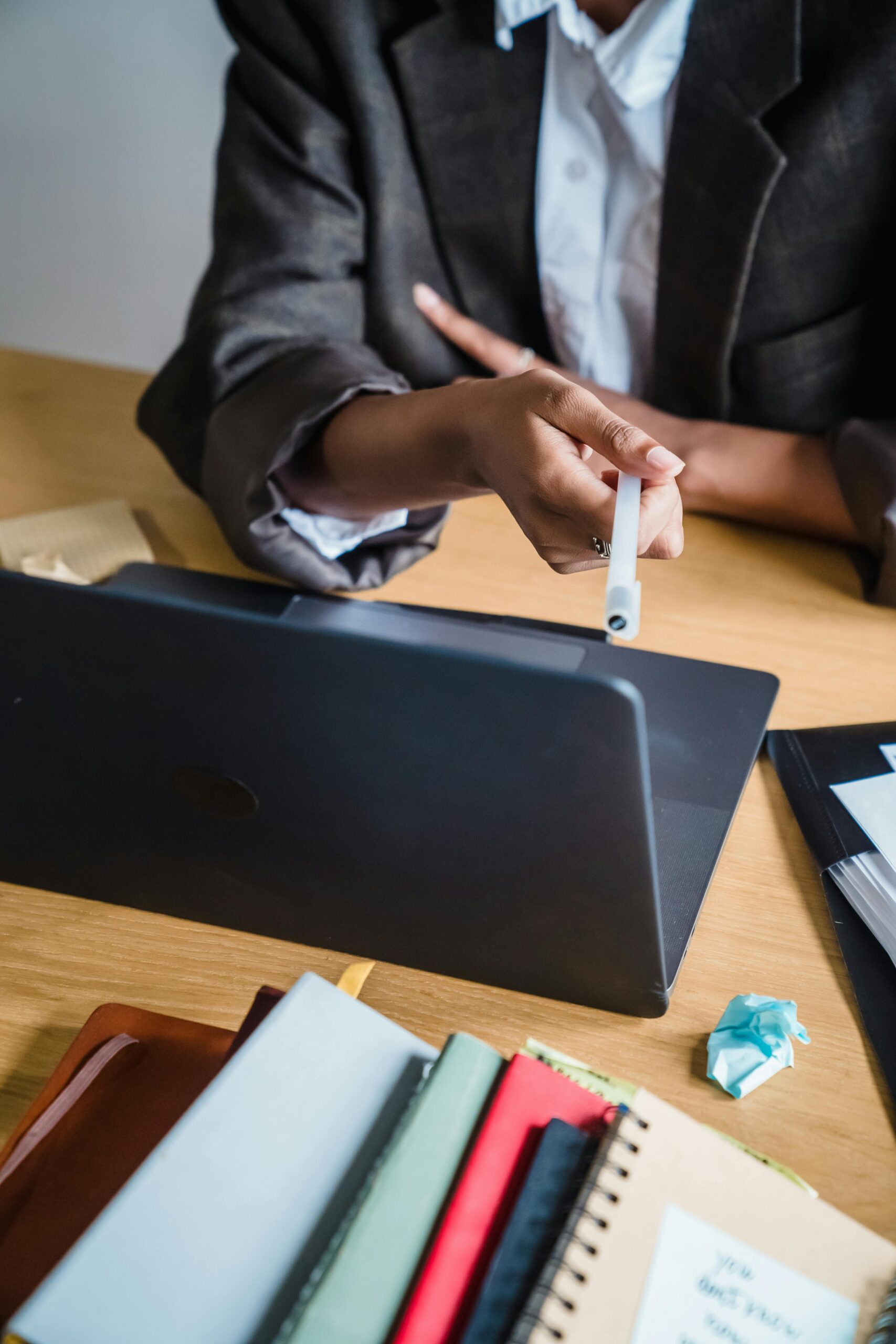 Female hand holding pen over laptop