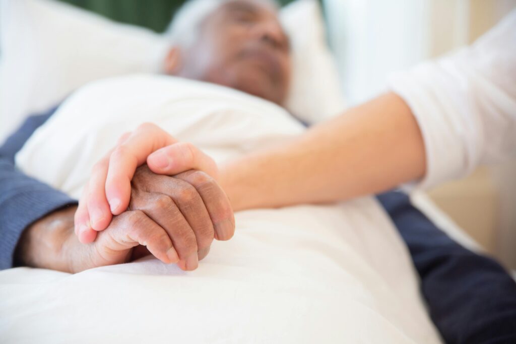 Young persons hand holding an old persons hand